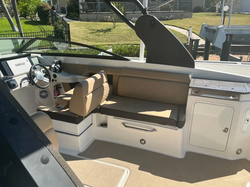 Slide: The Image of 2018 Sea Ray SDX 290 Outboard interior with beige seating and modern dashboard. - 11