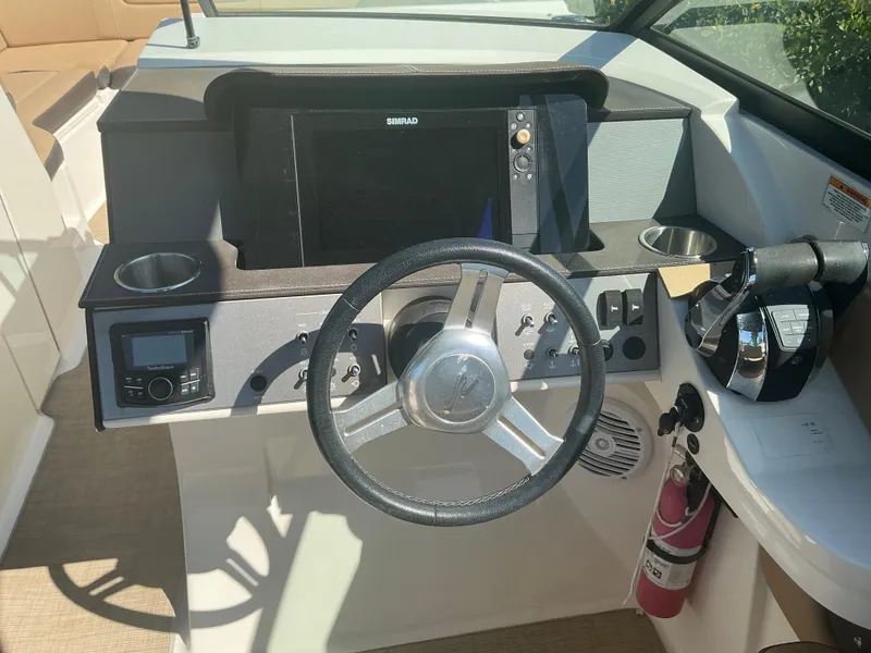Slide: The Image of 2018 Sea Ray SDX 290 Outboard dashboard with steering wheel, controls, and navigation system. - 19