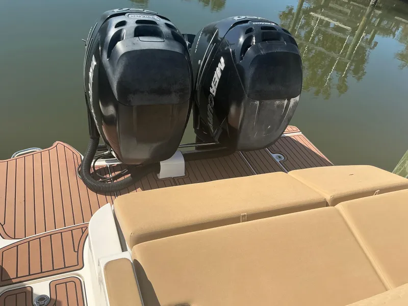 Slide: The Image of 2018 Sea Ray SDX 290 Outboard with twin engines and tan seating on a calm lake. - 23