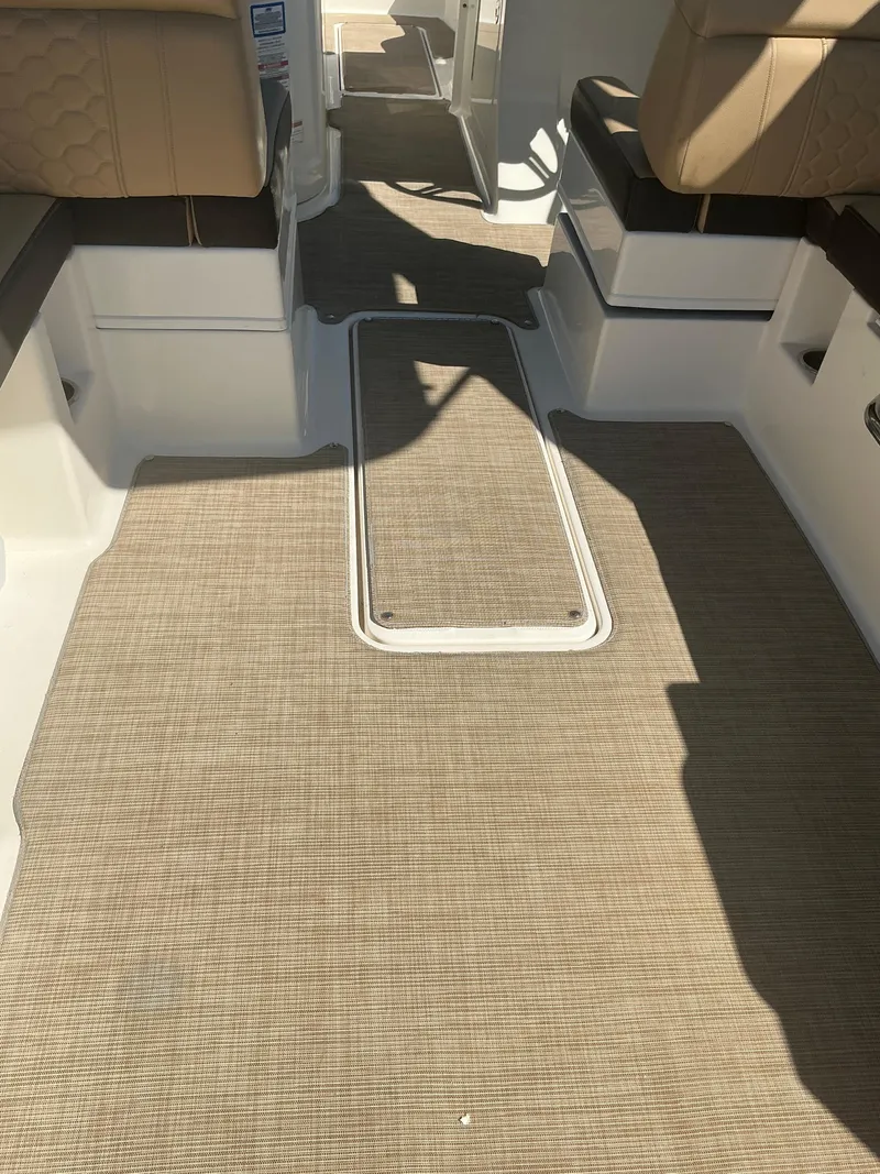Slide: The Image of 2018 Sea Ray SDX 290 Outboard interior with beige seating and carpeted flooring. - 31