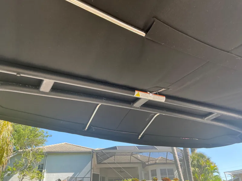 Slide: The Image of Black canopy of a 2018 Sea Ray SDX 290 Outboard boat, with a house in the background. - 33