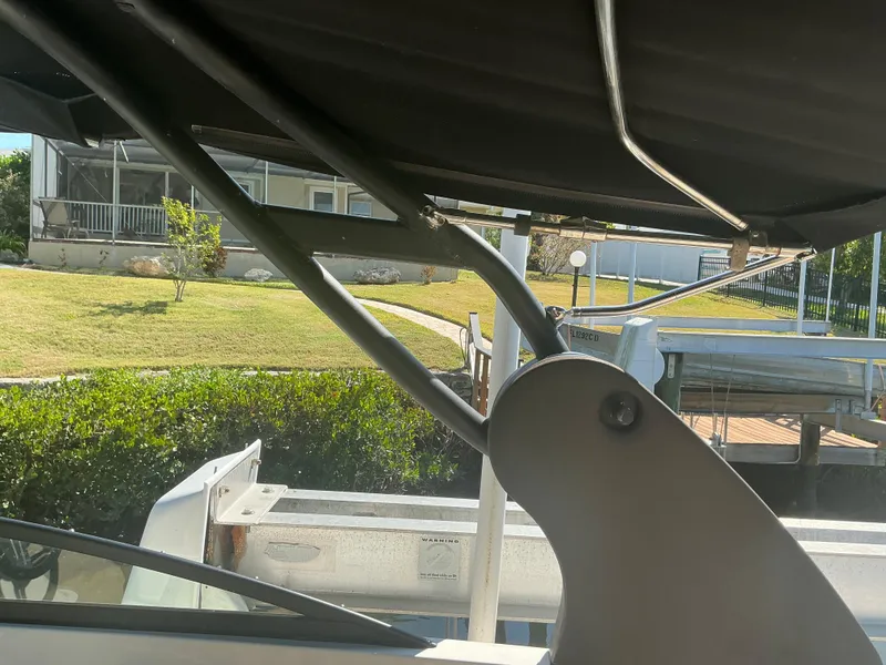 Slide: The Image of 2018 Sea Ray SDX 290 Outboard boat with canopy, docked near a grassy area. - 35