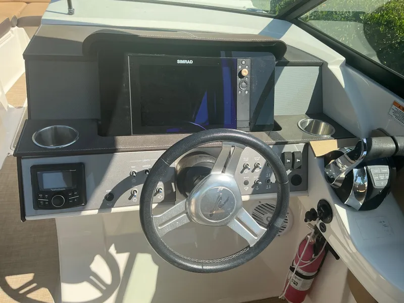 Slide: The Image of 2018 Sea Ray SDX 290 Outboard dashboard with steering wheel, controls, and navigation system. - 36