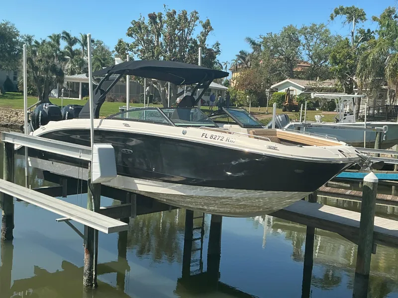 Slide: The Image of 2018 Sea Ray SDX 290 Outboard boat docked on a lift in a sunny marina. - 38