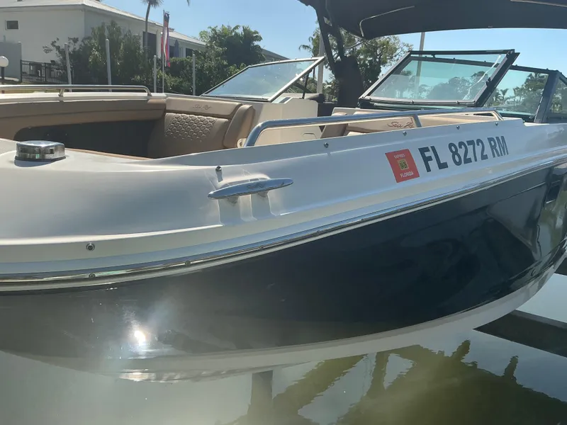 Slide: The Image of 2018 Sea Ray SDX 290 Outboard boat docked, featuring sleek design and open seating. - 4