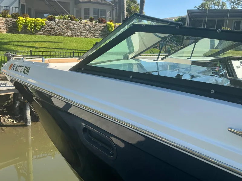 Slide: The Image of 2018 Sea Ray SDX 290 Outboard boat docked near a waterfront home. - 8