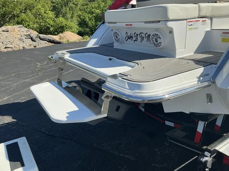 Slide: The Image of 2021 Cobalt R7 boat with extended swim platform and speakers, parked outdoors. - 3