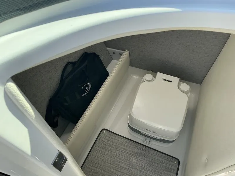 Slide: The Image of 2021 Cobalt R7 boat interior with portable toilet and storage bag. - 7