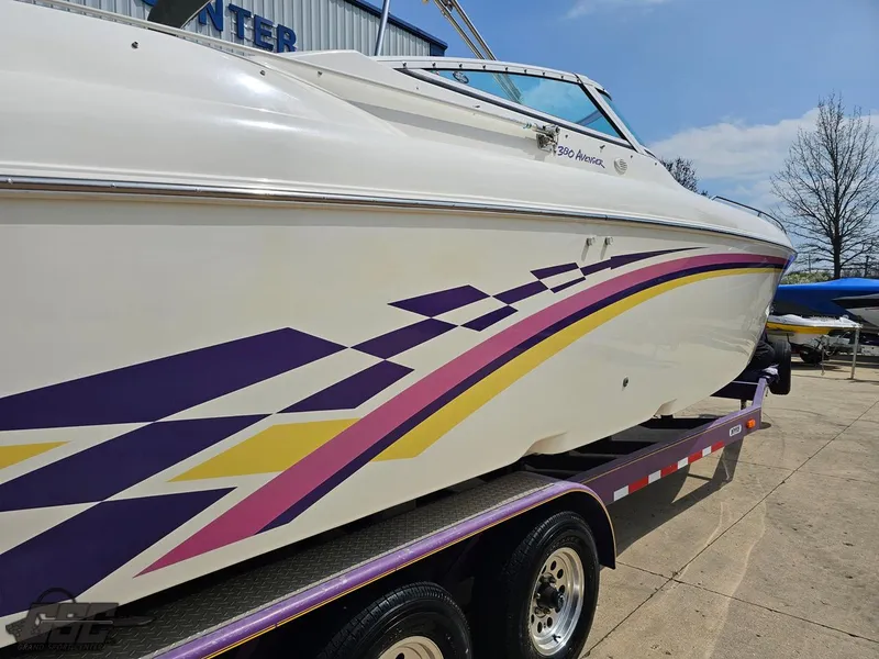 Slide: The Image of 1999 Powerquest 380 Avenger boat with colorful graphics on a trailer. - 10