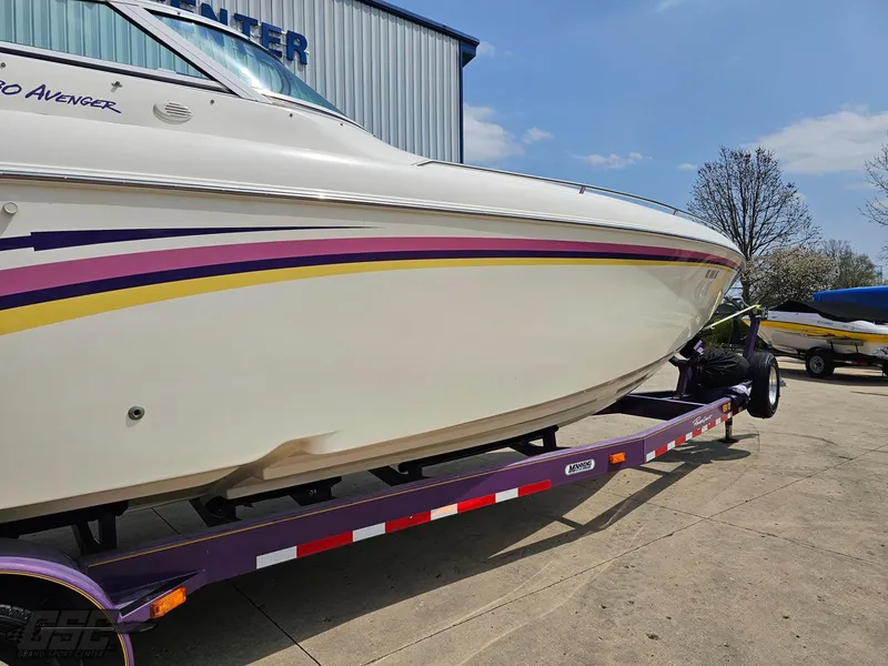 Slide: The Image of 1999 Powerquest 380 Avenger boat on trailer, featuring sleek design and vibrant stripes. - 11