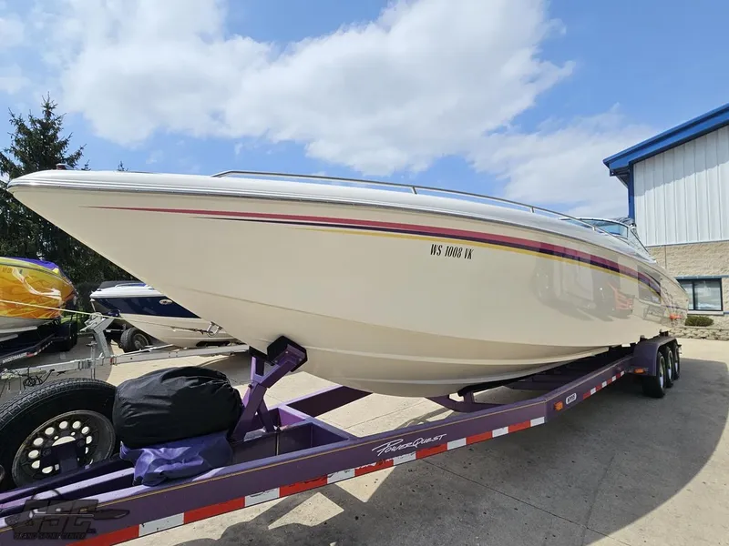 Slide: The Image of 1999 Powerquest 380 Avenger boat on trailer, parked outdoors under a partly cloudy sky. - 16