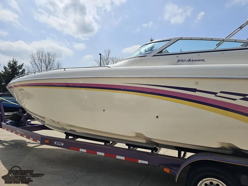 Slide: The Image of 1999 Powerquest 380 Avenger boat on trailer, featuring sleek design and colorful stripes. - 21