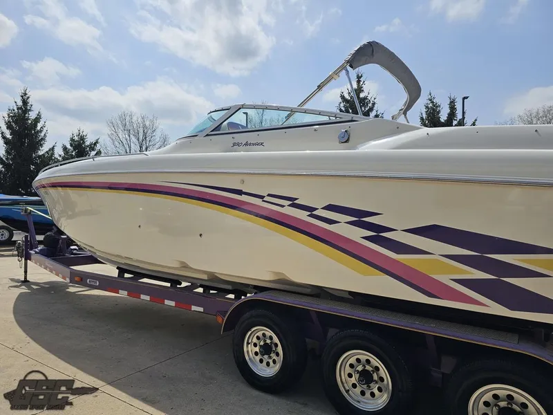 Slide: The Image of 1999 Powerquest 380 Avenger boat on trailer, featuring colorful side graphics. - 22