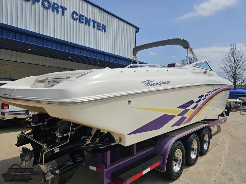 Slide: The Image of 1999 Powerquest 380 Avenger boat on trailer, parked outside a marine center. - 28
