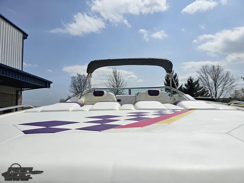 Slide: The Image of 1999 Powerquest 380 Avenger boat with checkered design under a clear blue sky. - 30