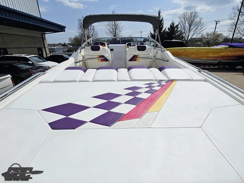 Slide: The Image of 1999 Powerquest 380 Avenger boat with colorful checkered upholstery design, docked outdoors. - 33