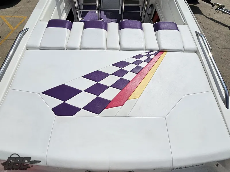 Slide: The Image of 1999 Powerquest 380 Avenger boat with colorful checkered pattern on white seating area. - 34