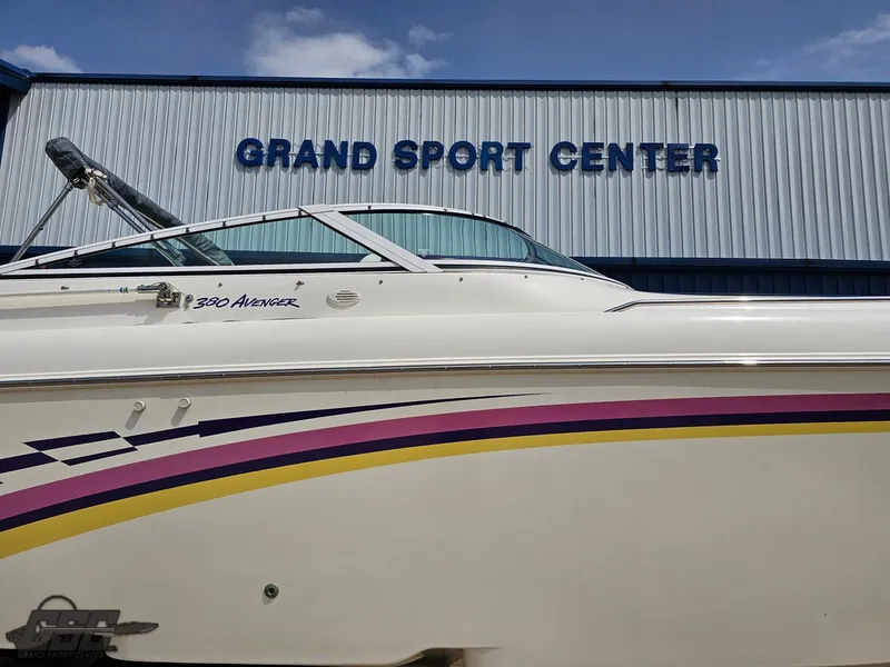 Slide: The Image of 1999 Powerquest 380 Avenger boat at Grand Sport Center, featuring colorful stripes. - 4