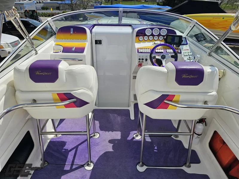 Slide: The Image of 1999 Powerquest 380 Avenger boat interior with purple and yellow accents, featuring dual seats and dashboard. - 42