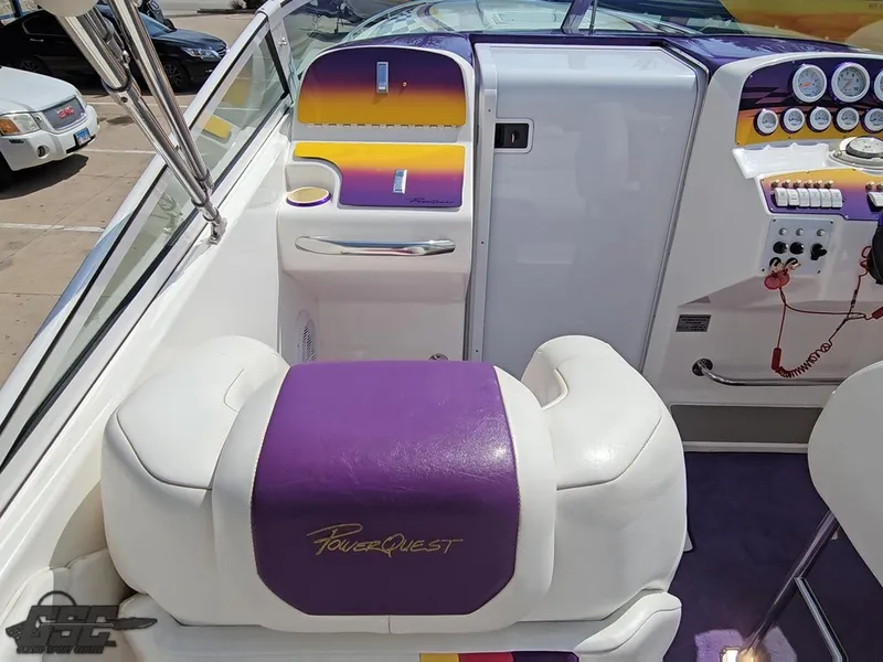 Slide: The Image of 1999 Powerquest 380 Avenger boat interior with purple and white seating, dashboard, and controls. - 47