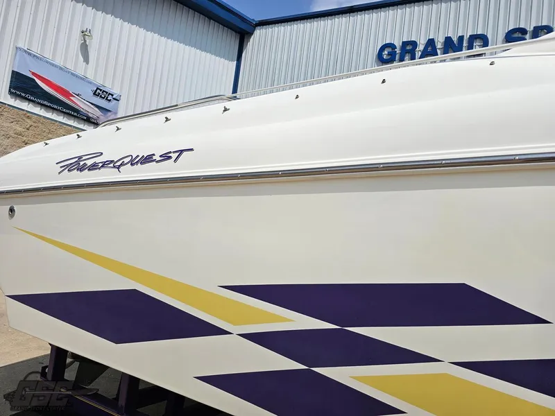 Slide: The Image of 1999 Powerquest 380 Avenger boat with purple and yellow graphics, displayed outdoors. - 7