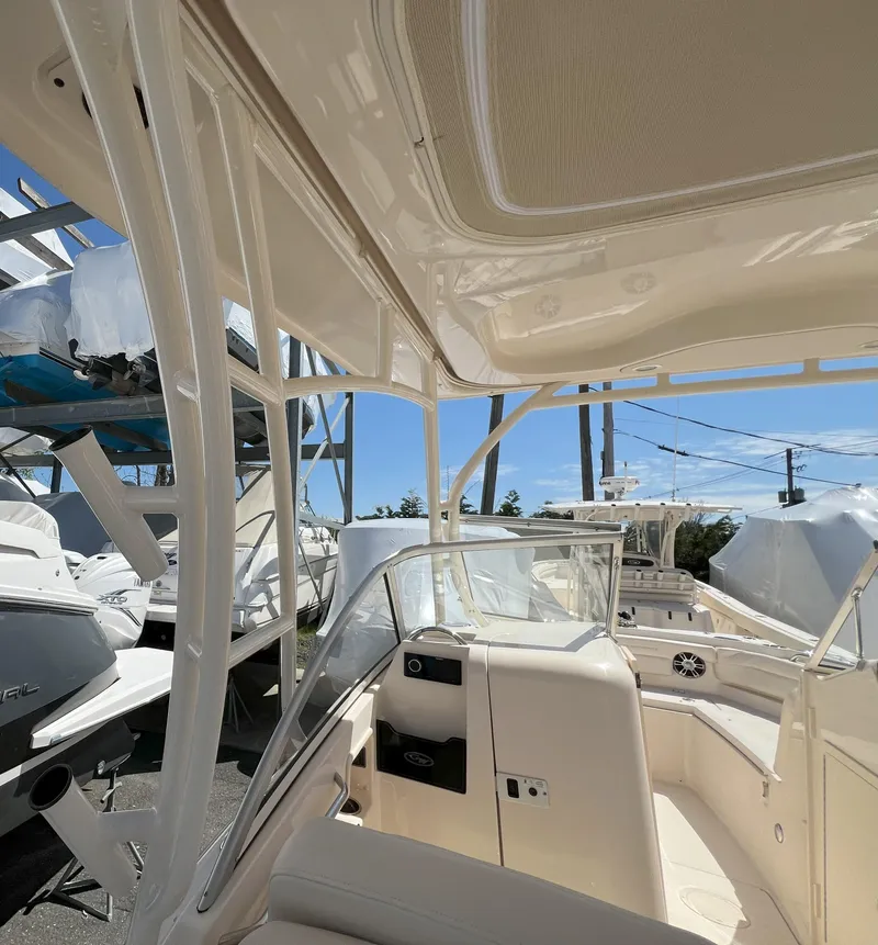 Slide: The Image of 2026 Grady-White GW 235 Freedom boat interior, showcasing seating and helm under a sunny sky. - 12
