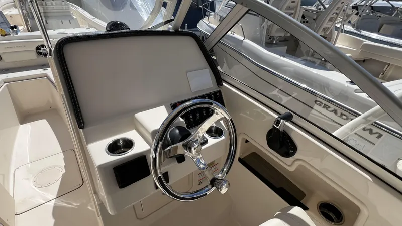Slide: The Image of 2026 Grady-White GW 235 Freedom boat helm with steering wheel and controls. - 14