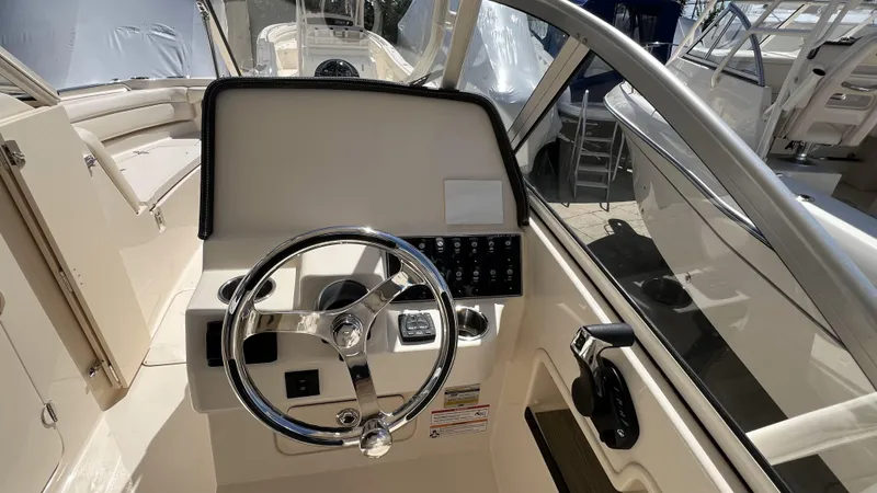 Slide: The Image of 2026 Grady-White GW 235 Freedom boat helm with steering wheel and control panel. - 15