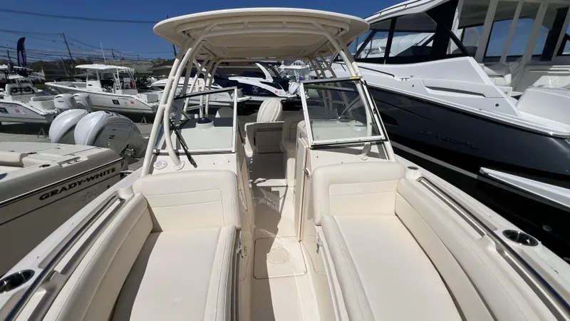 Slide: The Image of 2026 Grady-White GW 235 Freedom boat interior with seating and helm, docked at marina. - 23