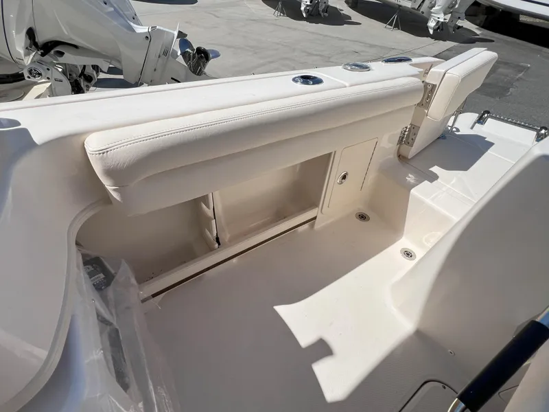 Slide: The Image of 2026 Grady-White GW 235 Freedom boat interior with white seating and storage compartments. - 5