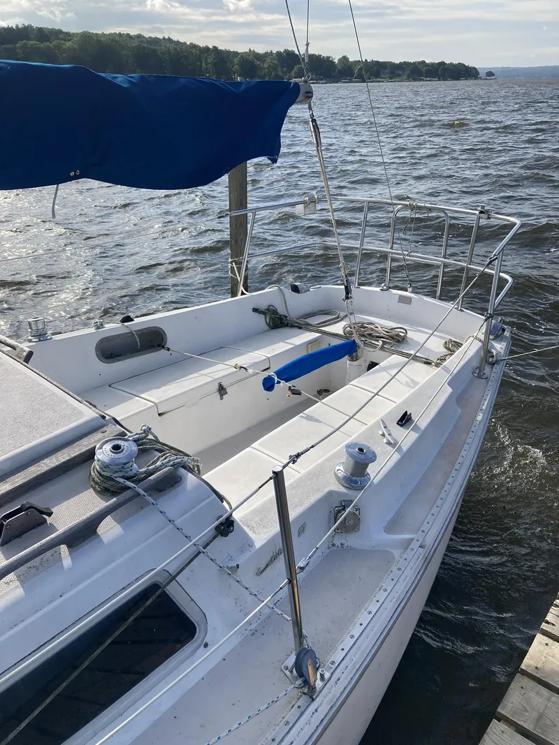 Slide: The Image of 1980 Catalina Cat 27 sailboat docked on a lake with blue sail cover. - 1