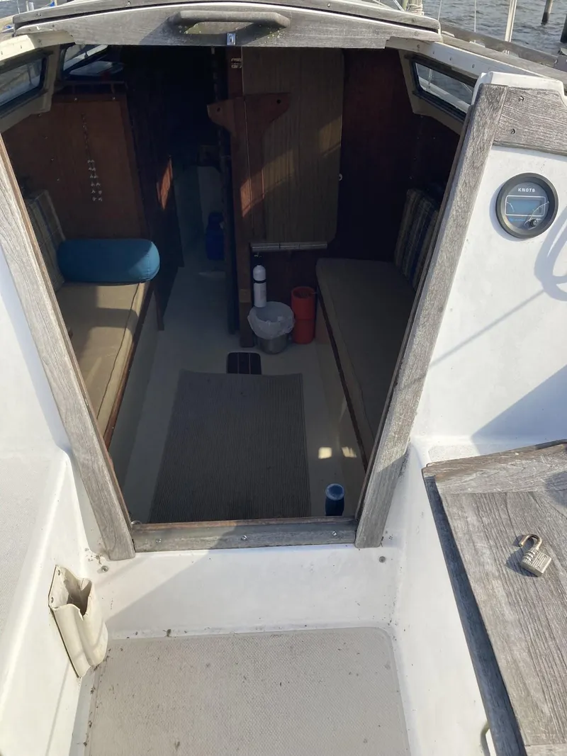 Slide: The Image of 1980 Catalina Cat 27 sailboat interior with seating and wooden accents. - 2