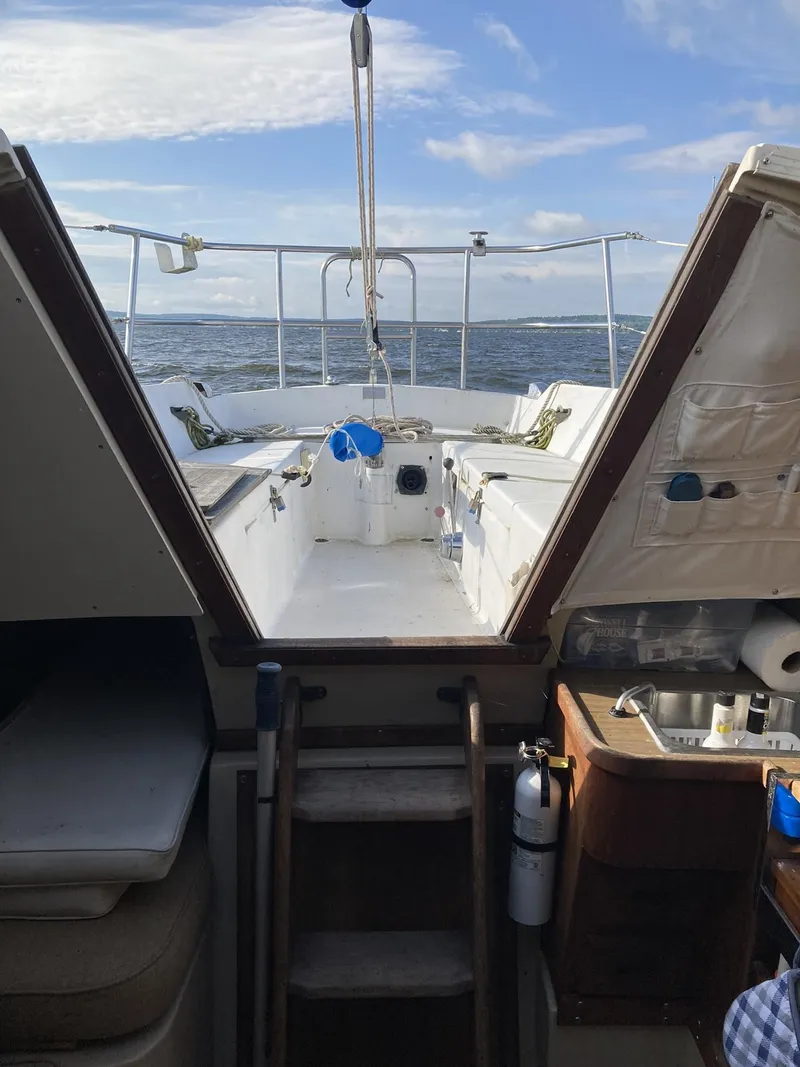 Slide: The Image of 1980 Catalina Cat 27 sailboat interior with ocean view through open hatch. - 6