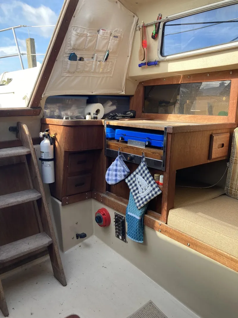 Slide: The Image of Interior of a 1980 Catalina Cat 27 sailboat with wooden cabinetry and nautical accessories. - 7