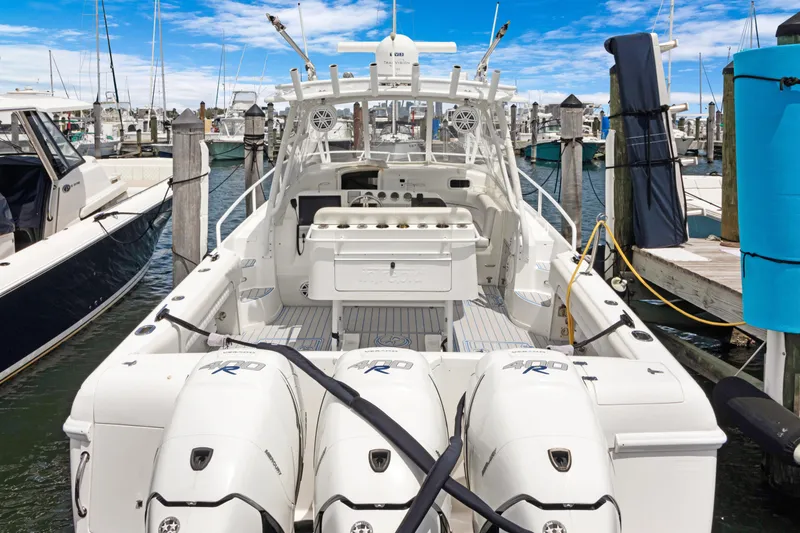 The Image of 2004 Intrepid 377 Walkaround boat docked with triple outboard engines. - 0