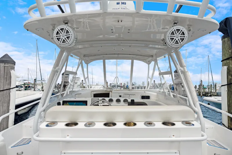 Slide: The Image of 2004 Intrepid 377 Walkaround boat interior with helm, speakers, and marina view. - 14