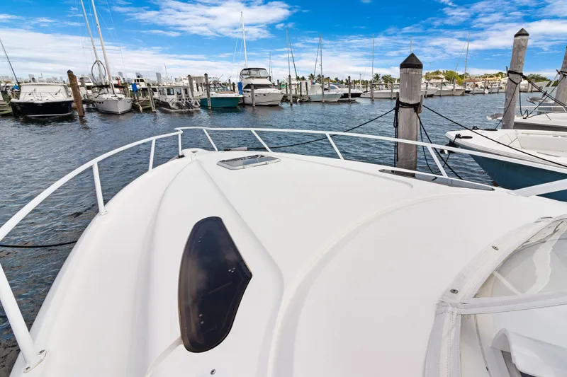 Slide: The Image of 2004 Intrepid 377 Walkaround boat docked in a marina under a clear blue sky. - 22