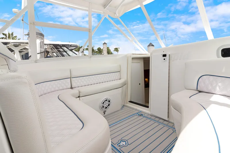 Slide: The Image of 2004 Intrepid 377 Walkaround boat interior with white seating and open cabin door. - 27