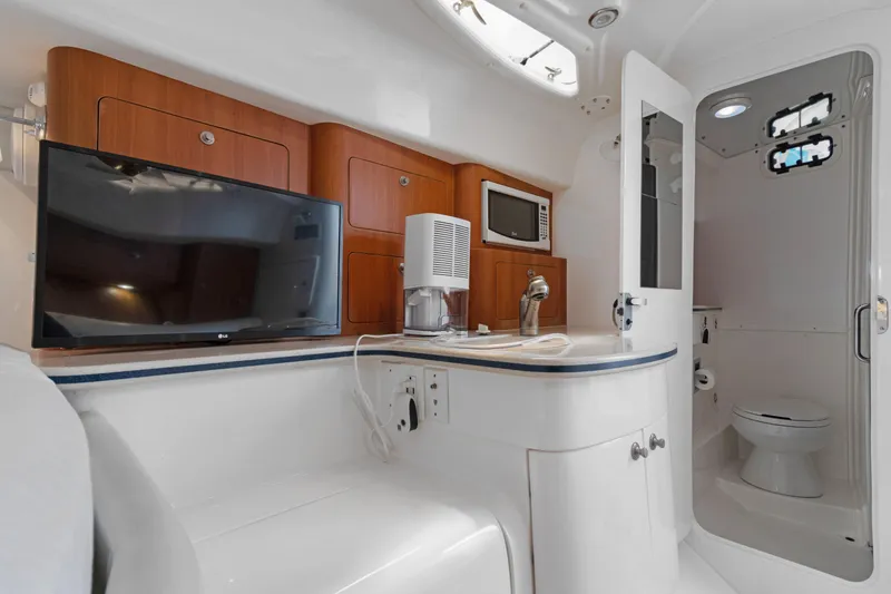Slide: The Image of 2004 Intrepid 377 Walkaround cabin interior with TV, kitchenette, and bathroom. - 38