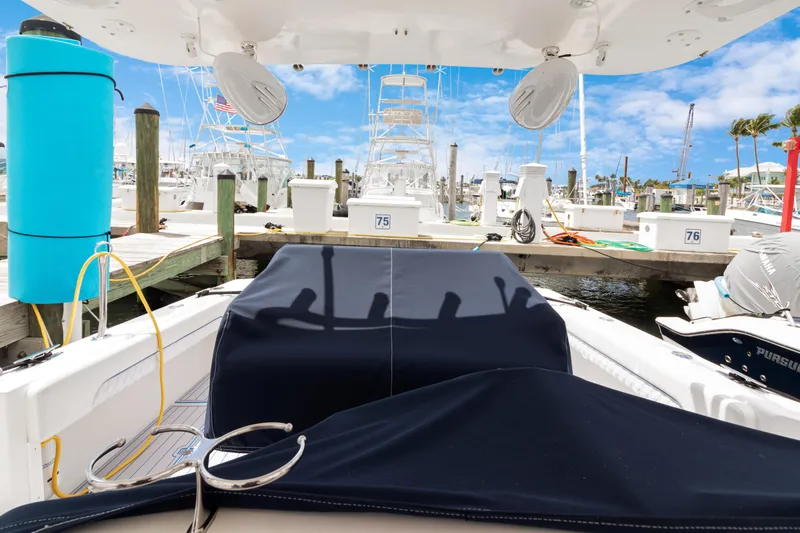 Slide: The Image of 2004 Intrepid 377 Walkaround boat docked at marina with blue cover and clear sky. - 44