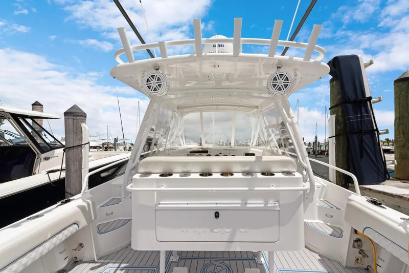 Slide: The Image of 2004 Intrepid 377 Walkaround boat docked, featuring spacious deck and fishing rod holders. - 46