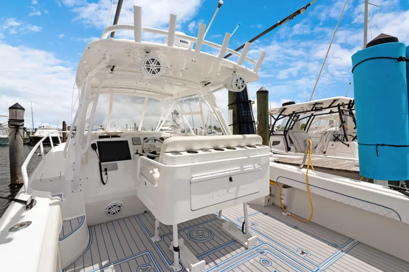 Slide: The Image of 2004 Intrepid 377 Walkaround boat docked, featuring spacious deck and modern equipment under a clear sky. - 47