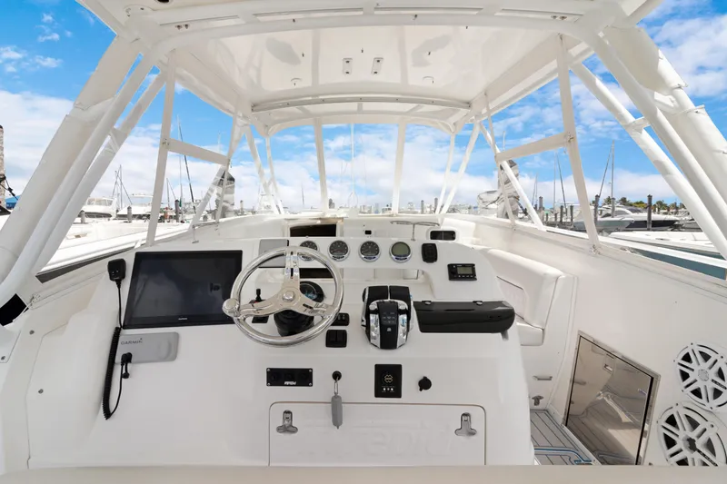 Slide: The Image of 2004 Intrepid 377 Walkaround boat helm with steering wheel, controls, and navigation equipment. - 5