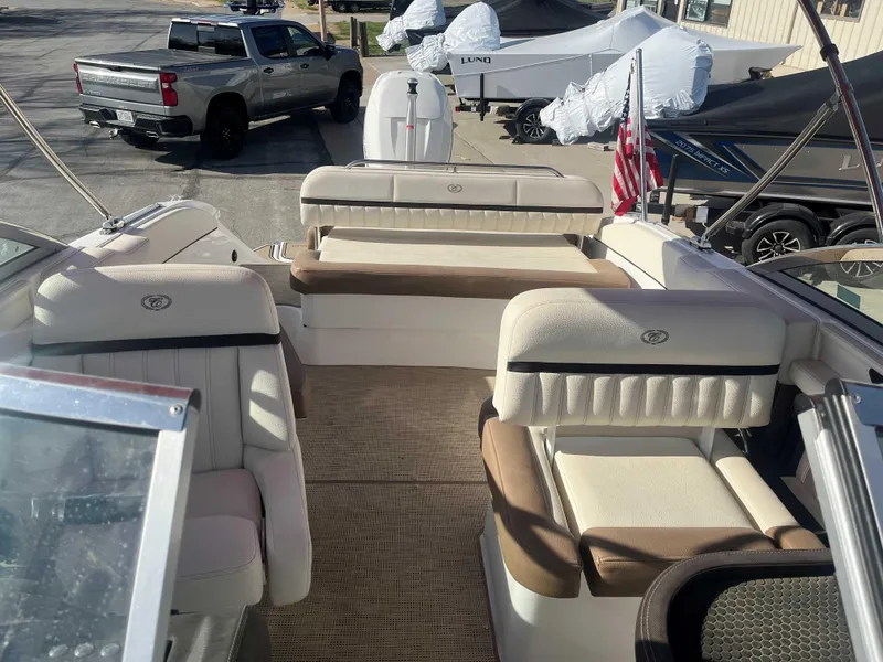 Slide: The Image of 2019 Cobalt 23 SC boat interior with seating, parked in a marina. - 3