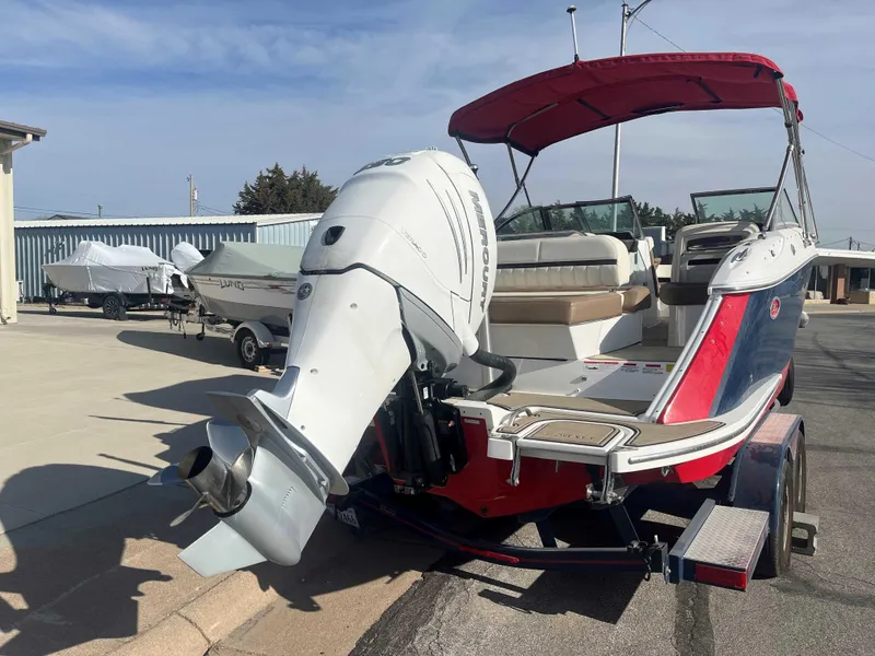 Slide: The Image of 2019 Cobalt 23 SC boat with outboard motor and red canopy on a trailer. - 4