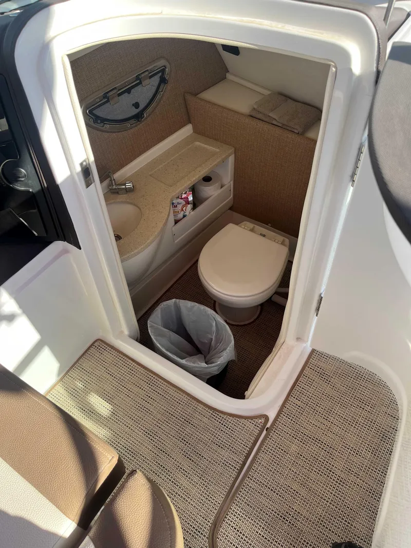 Slide: The Image of 2019 Cobalt 23 SC boat interior with compact bathroom, featuring toilet and sink. - 5