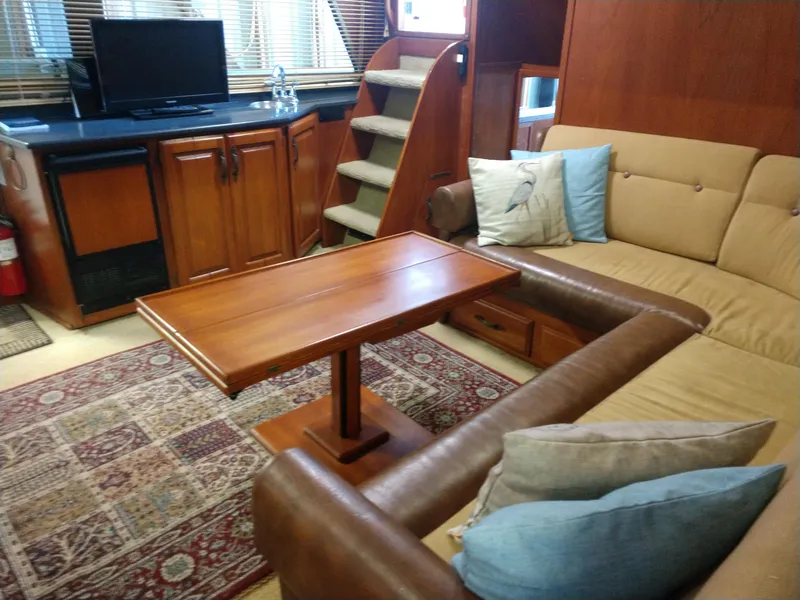 Slide: The Image of 1981 Tollycraft 43 Motoryacht interior with cozy seating, wooden table, and TV. - 13