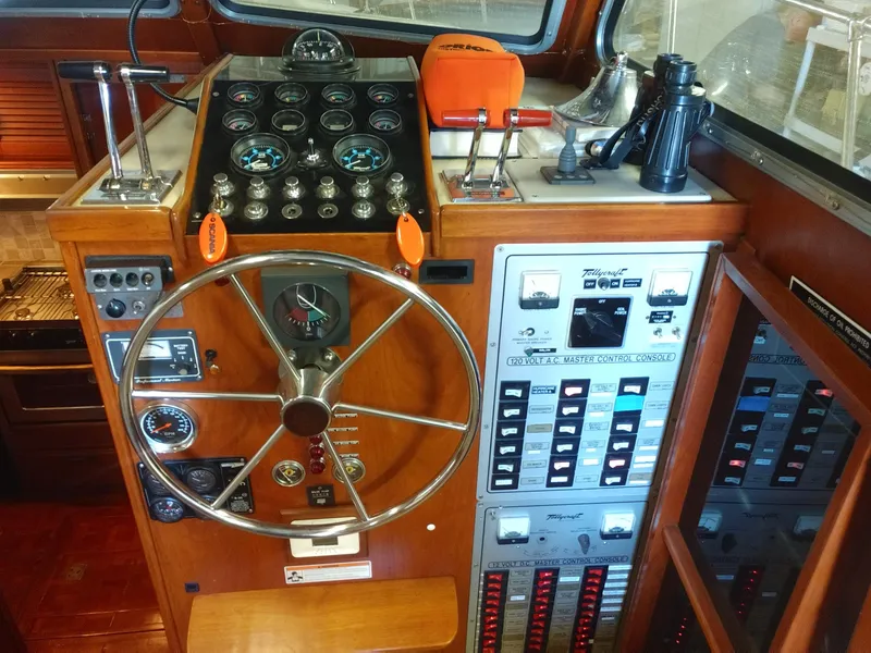 Slide: The Image of 1981 Tollycraft 43 Motoryacht helm with steering wheel, gauges, and control panels. - 16