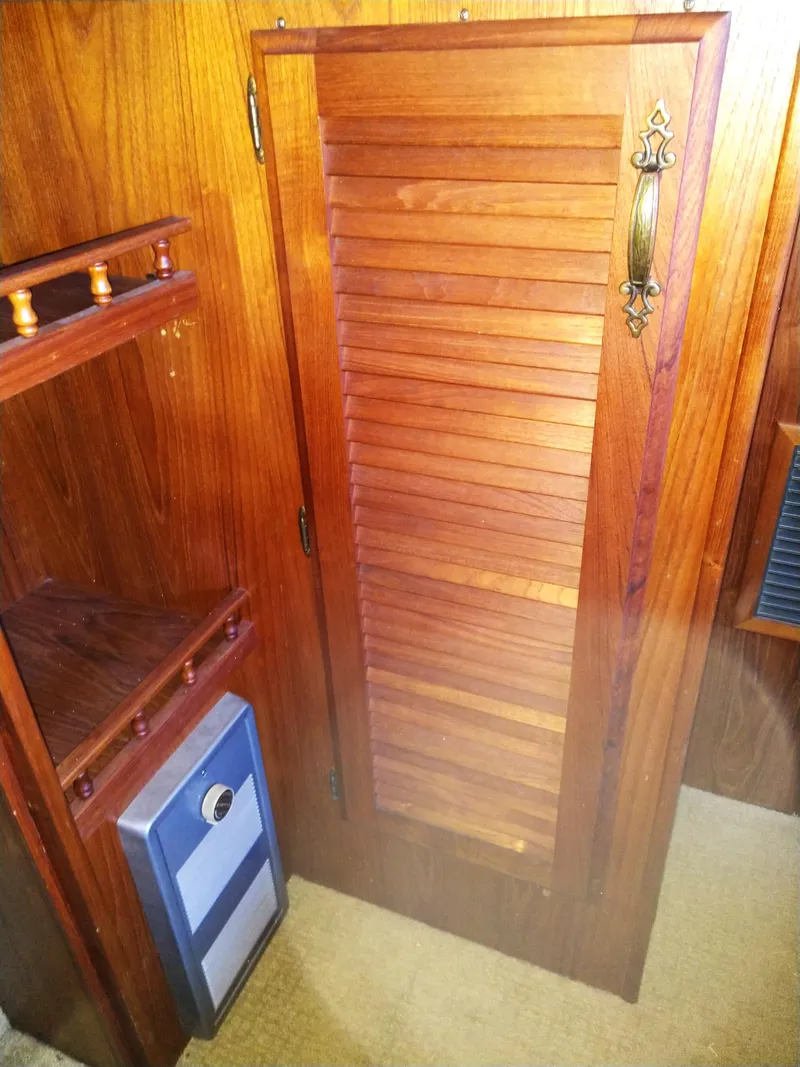 Slide: The Image of 1981 Tollycraft 43 Motoryacht interior with wooden louvered door and brass handle. - 23
