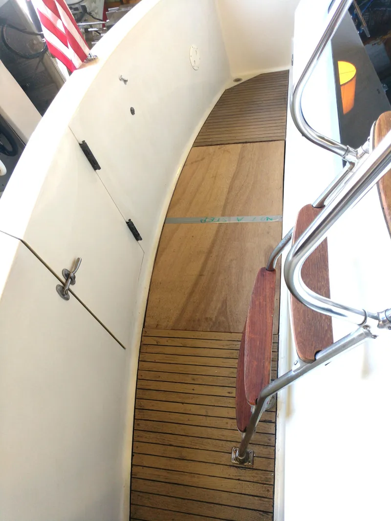 Slide: The Image of 1981 Tollycraft 43 Motoryacht deck with wooden flooring and metal railings. - 37